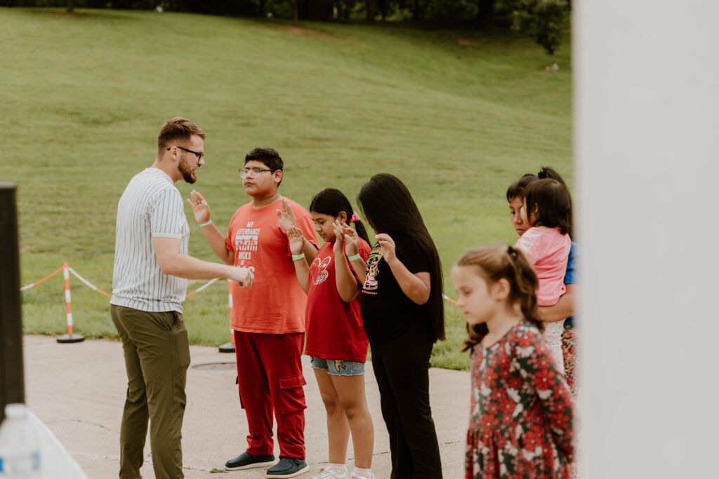Rodney praying with young people during an outdoor ministry outreach